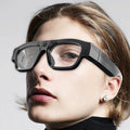 Black head-mounted smart Bluetooth glasses with a camera lens and transparent lens, shown on a model.