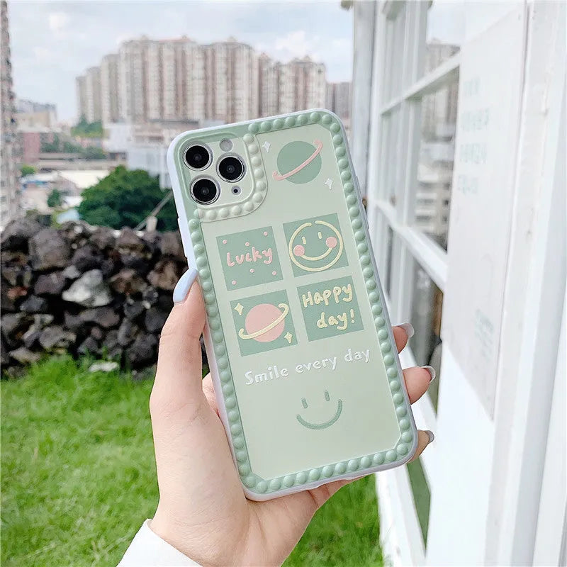 Green TPU phone case with geometric smiley face and polka dot pattern for multiple iPhone models.