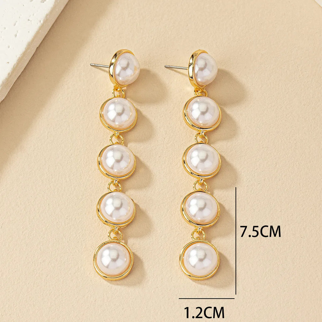 White long pearl tassel drop earrings made of electroplated metal with water flow design on white background