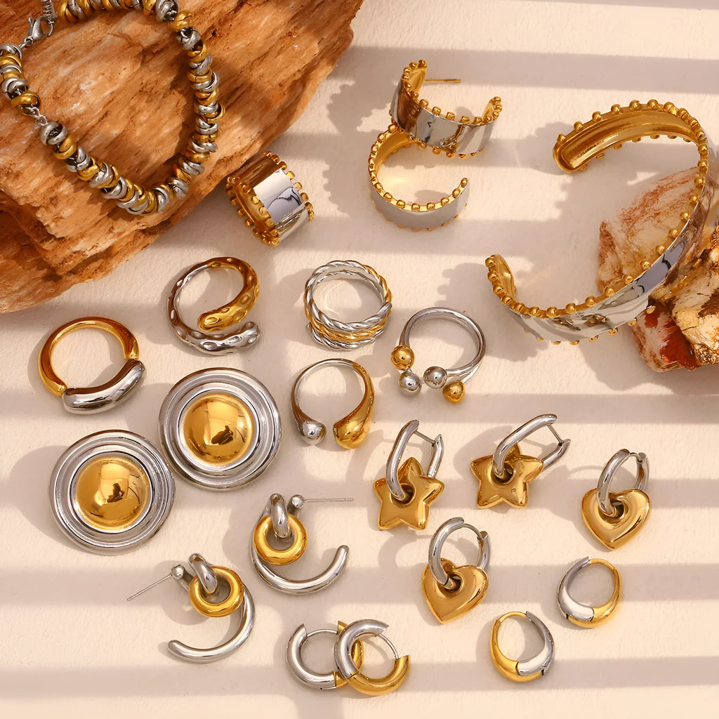 Gold geometric stainless steel jewellery set showing earrings, bracelet, and necklace on a plain background.