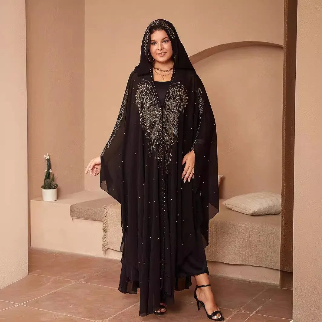 A woman wearing a long purple chiffon cape with rhinestone beading draped over the shoulders.