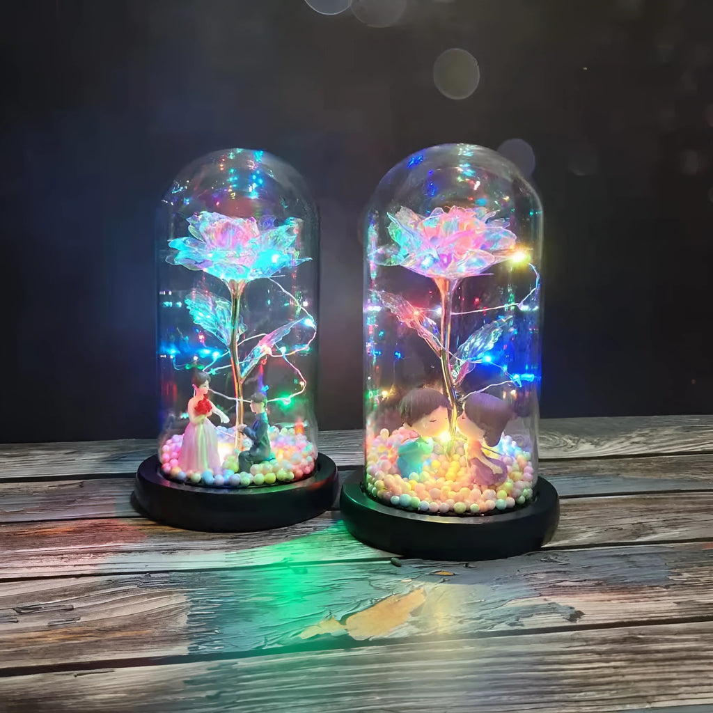 Artificial gold rose in clear glass dome on black base with LED lights for home decor