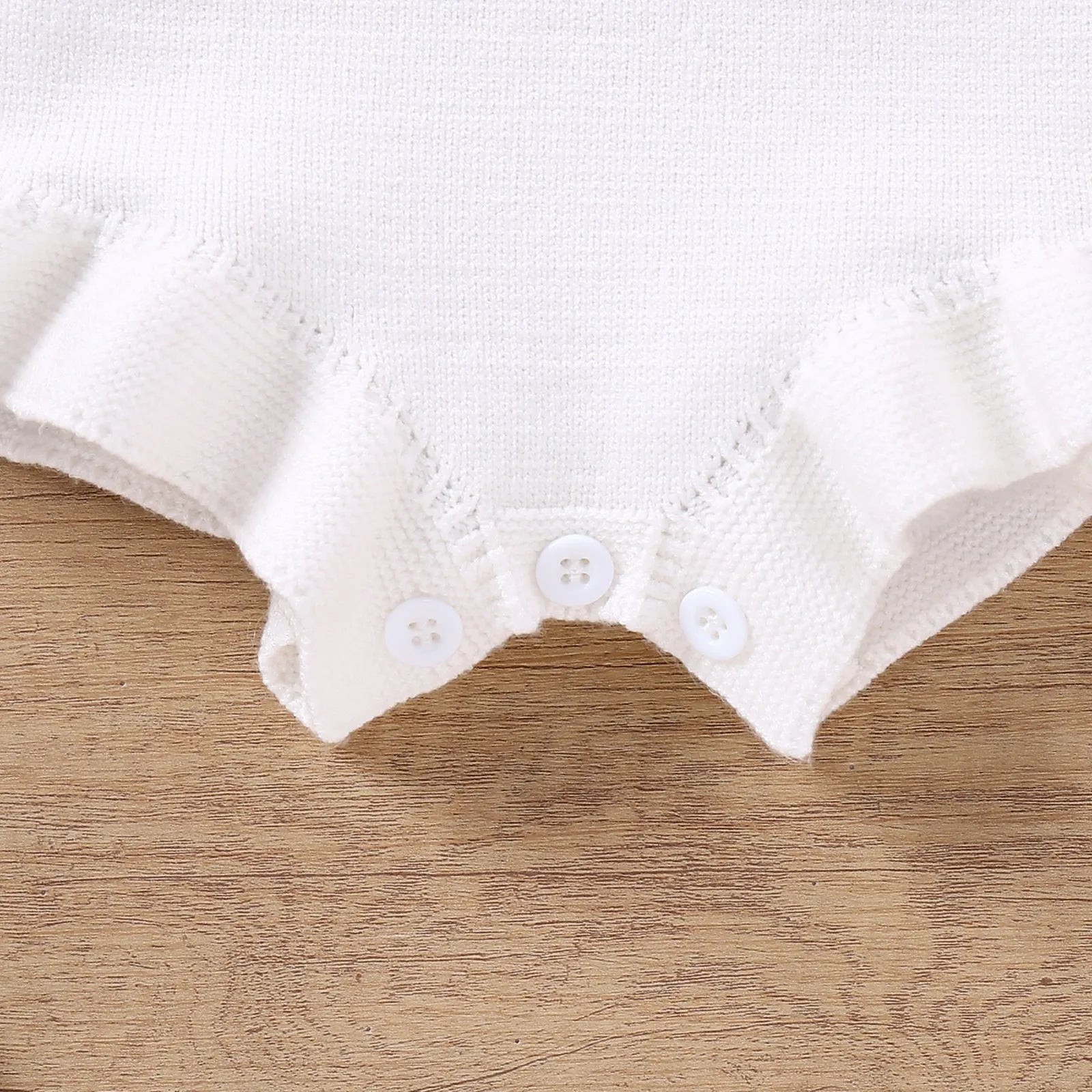 Baby girl sling romper in white with bow embroidery on wool blend fabric.