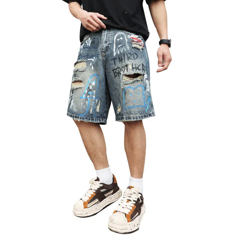 Blue men's ripped denim shorts with graffiti design and straight leg.