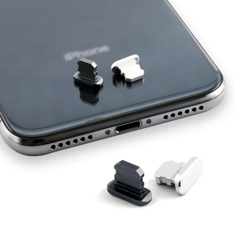 Aluminium alloy iPhone charging port dust plug in various colours on a dark background