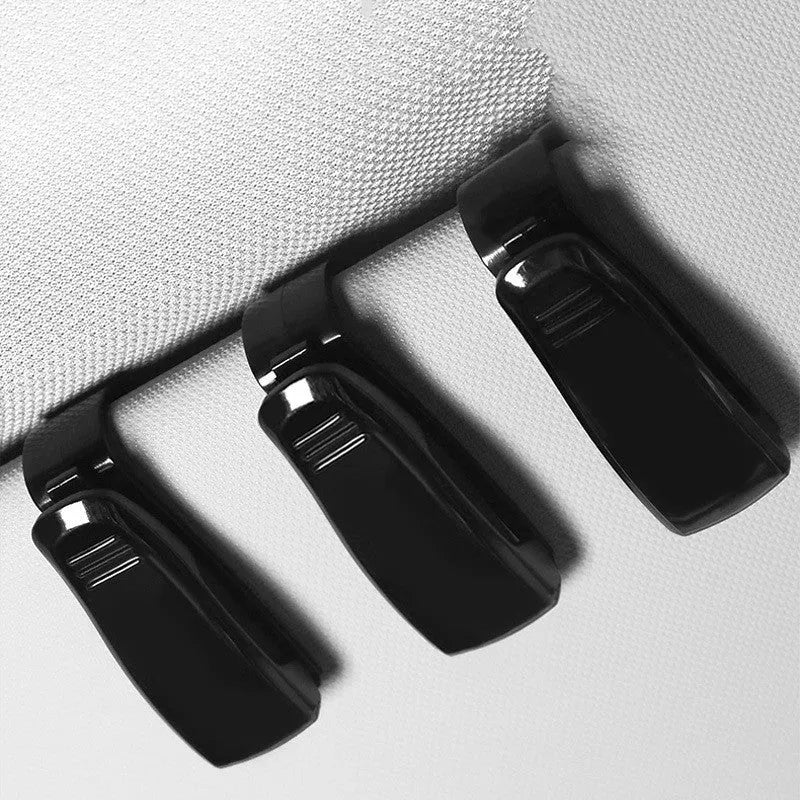 Black plastic car sunshade clip holder for glasses frames and cards measuring 6.5 by 2.3 centimetres