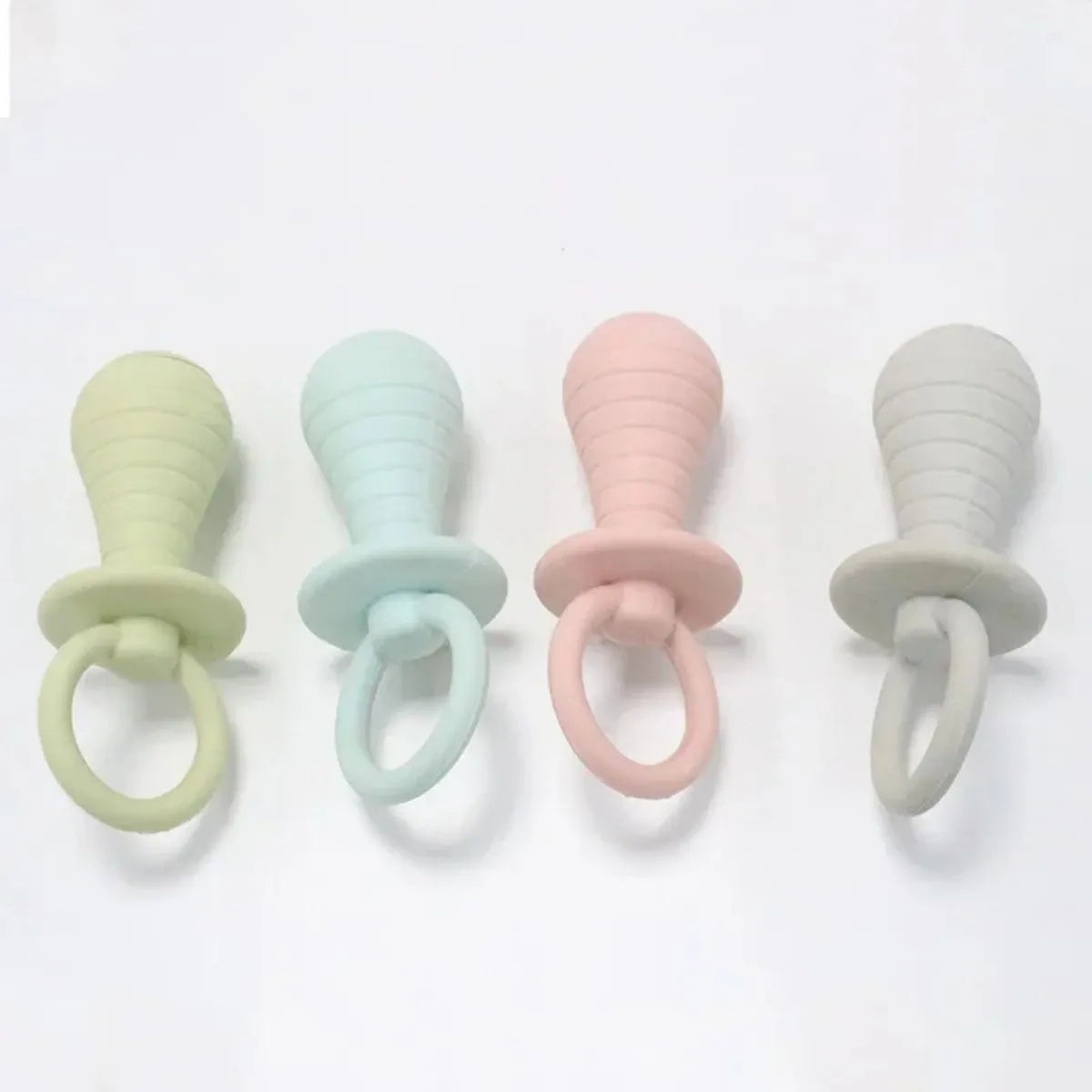 Four TPR rubber pet pacifier chew toys with squeakers in blue, grey, green, and pink colours