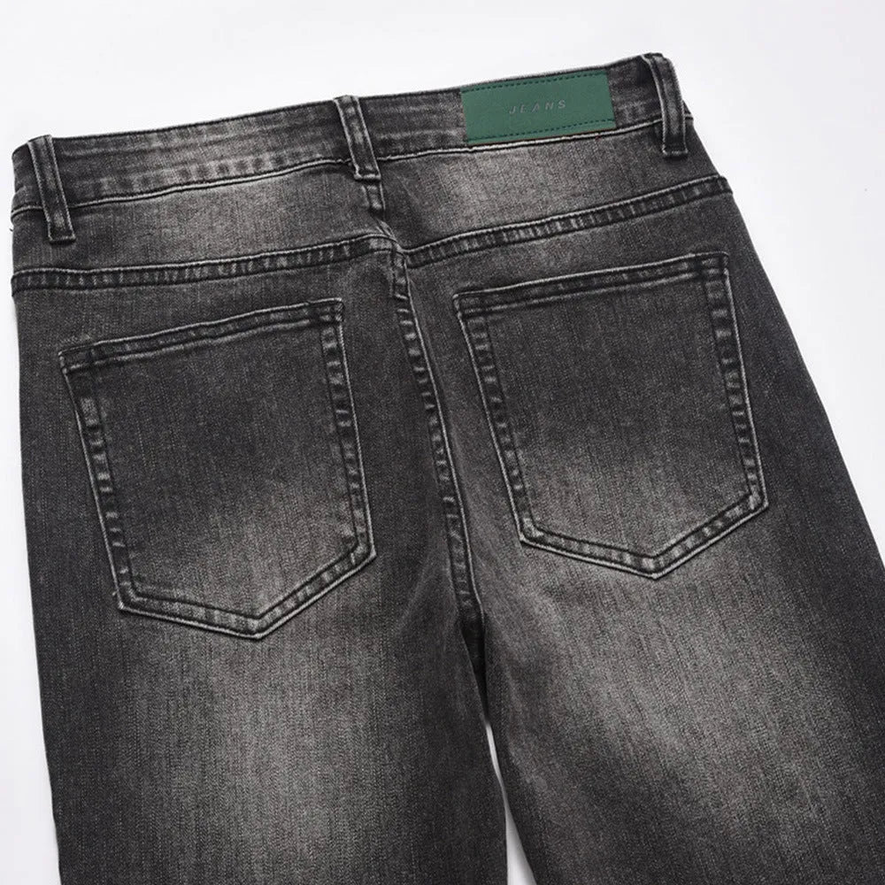 Men's black washed denim jeans on a flat surface showing full leg and pocket details