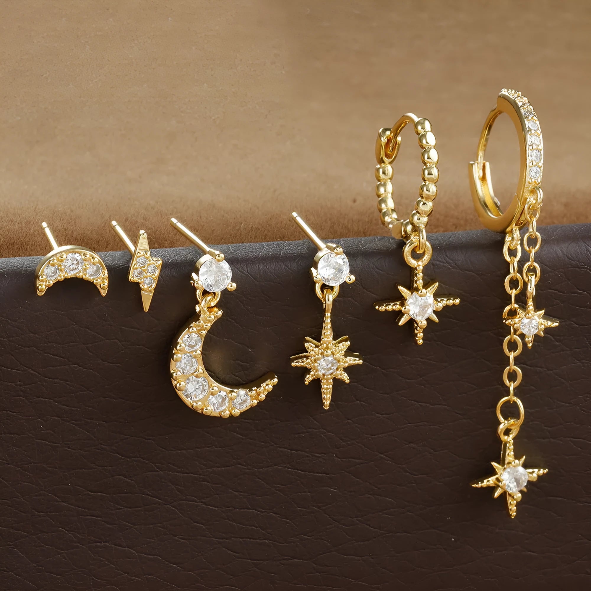 Six gold-coloured chain tassel earrings with zircon stones arranged together