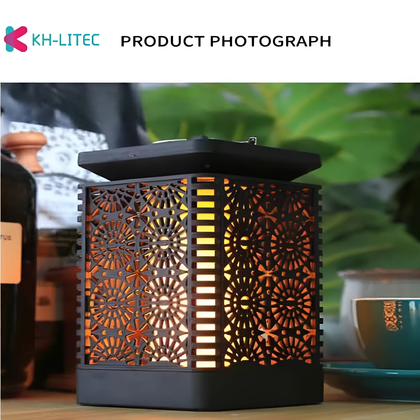 Four black solar-powered outdoor torch lights with flickering LED flame effect, placed on a garden patio.