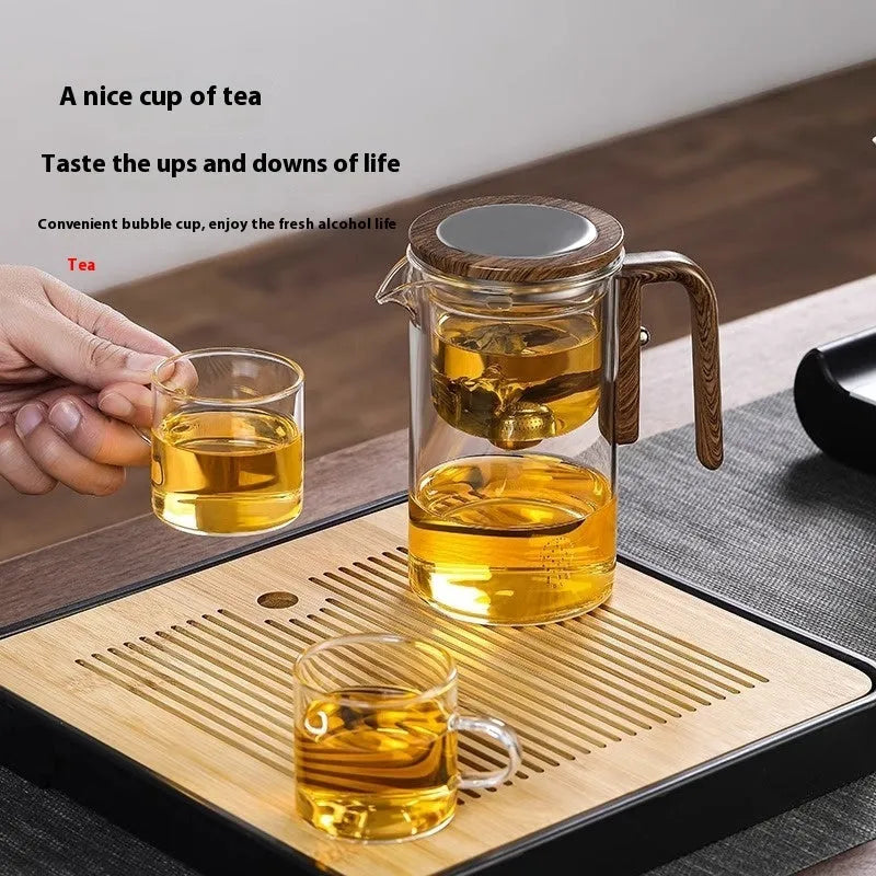 Glass teapot with wooden handle showing magnetic separation inner container and drip-free spout.
