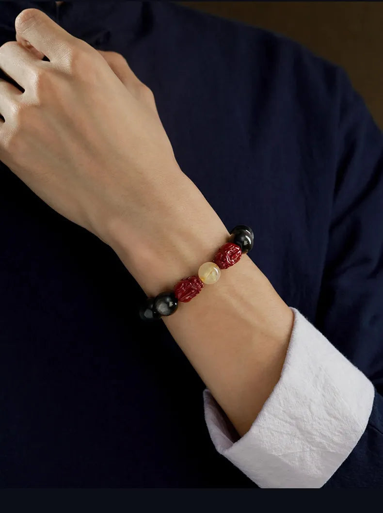 Carved cinnabar bead bracelet with animal zodiac modelling in gold obsidian and silver stone colours.