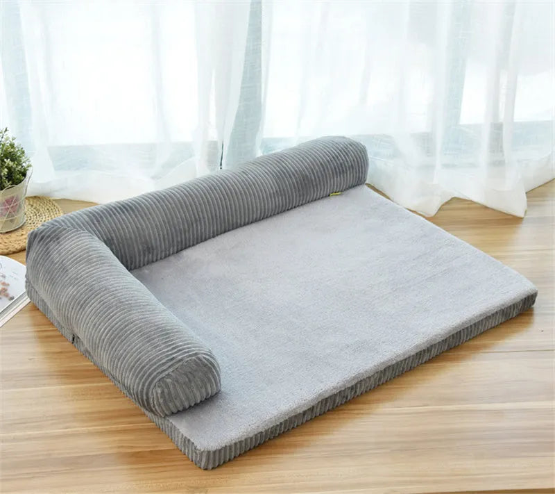 Corduroy dog sofa bed with bolster sides on a wooden floor, showing grey colour option in large size.