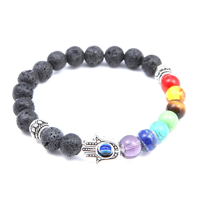 Natural volcanic rock hand chain with seven chakra stones and blue eye bead on a white background