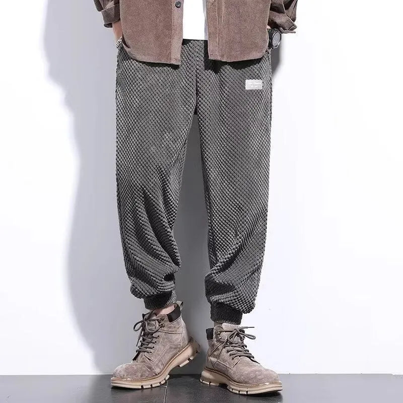 Man wearing grey straight-leg sweatpants with an ankle tie closure.