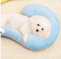 Blue U-shaped cat pillow with neck support in a moon design on a wooden floor.