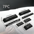 Seven black frosted metal building blocks arranged for architectural model assembly