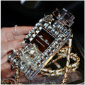 Perfume bottle and bow design iPhone case with metal chain, in matte black TPU, shown fitted on an iPhone.