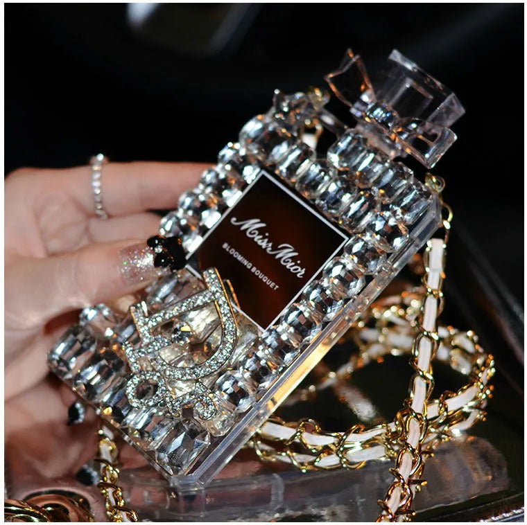 Perfume bottle and bow design iPhone case with metal chain, in matte black TPU, shown fitted on an iPhone.