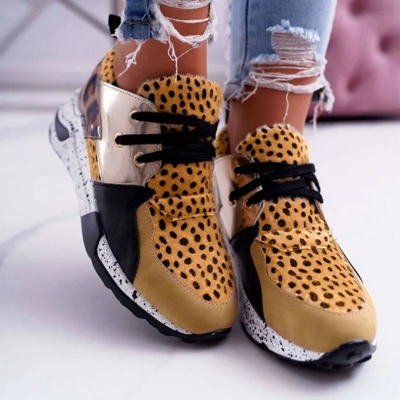 Women's casual wedge heel sneakers in suede, showing round toe and low-cut profile on a wooden floor.