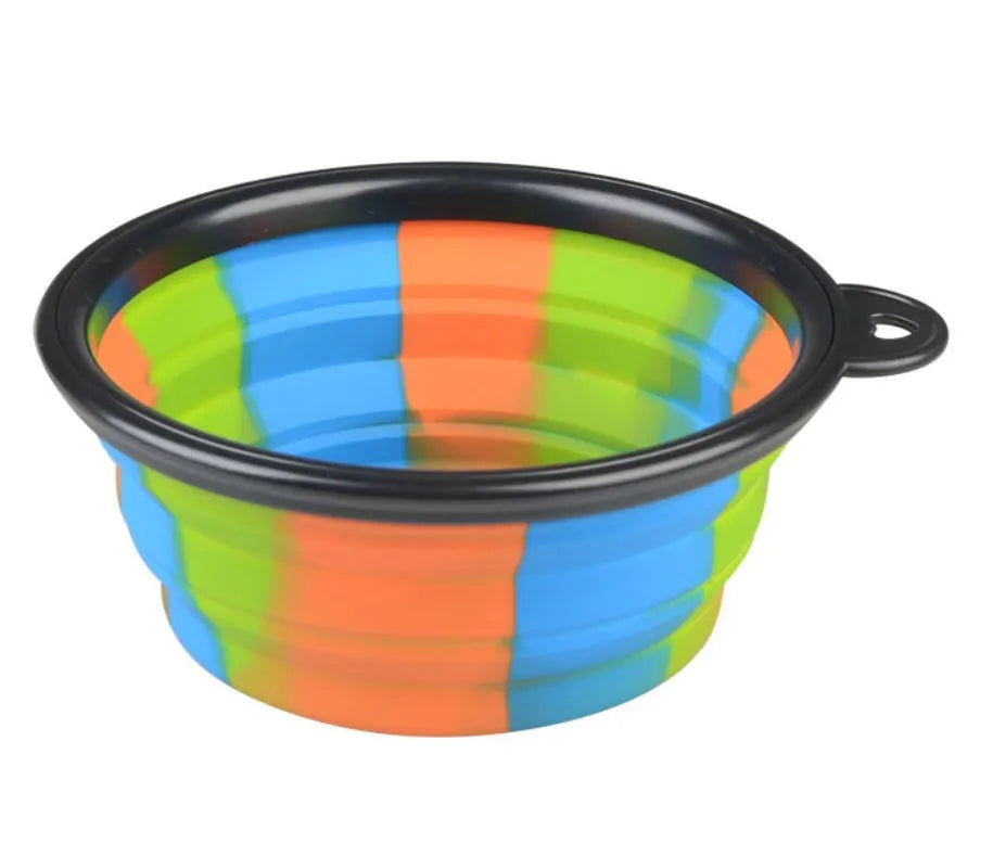 Collapsible silicone dog bowl in camouflage pattern folded flat on green surface