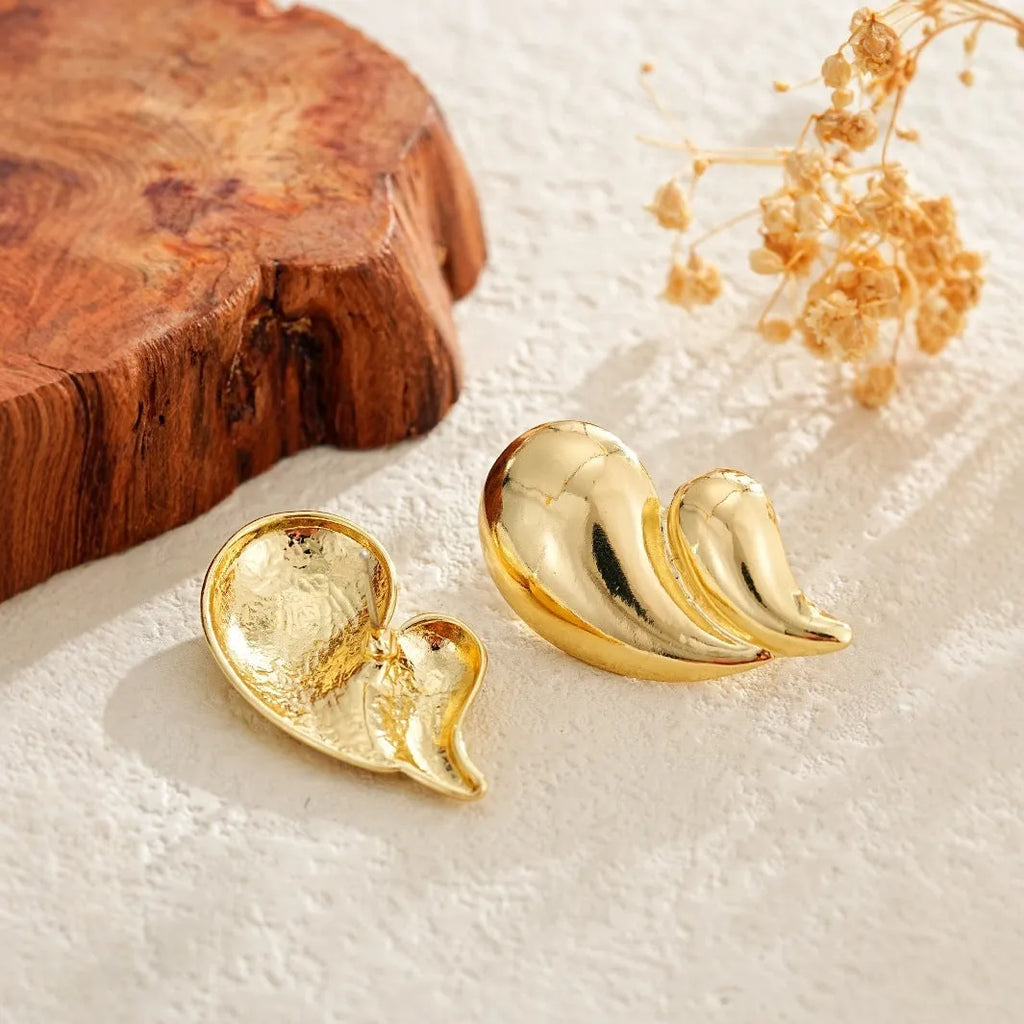 Gold water droplet minimalist dangle drop earrings on a white background