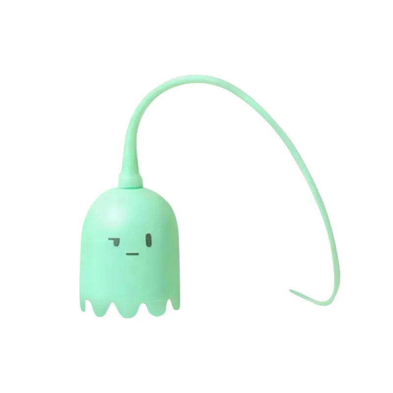 Green automatic cat wand toy with swinging silicone tails on a wooden floor.