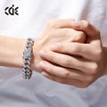 Men's gold Cuban chain bracelet with geometric alloy pendant set with a zircon stone on a neutral background
