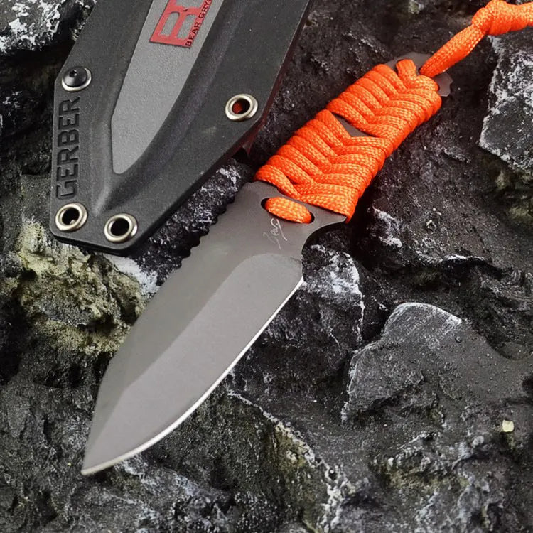 Straight camping survival knife with binding rope handle next to ABS sheath