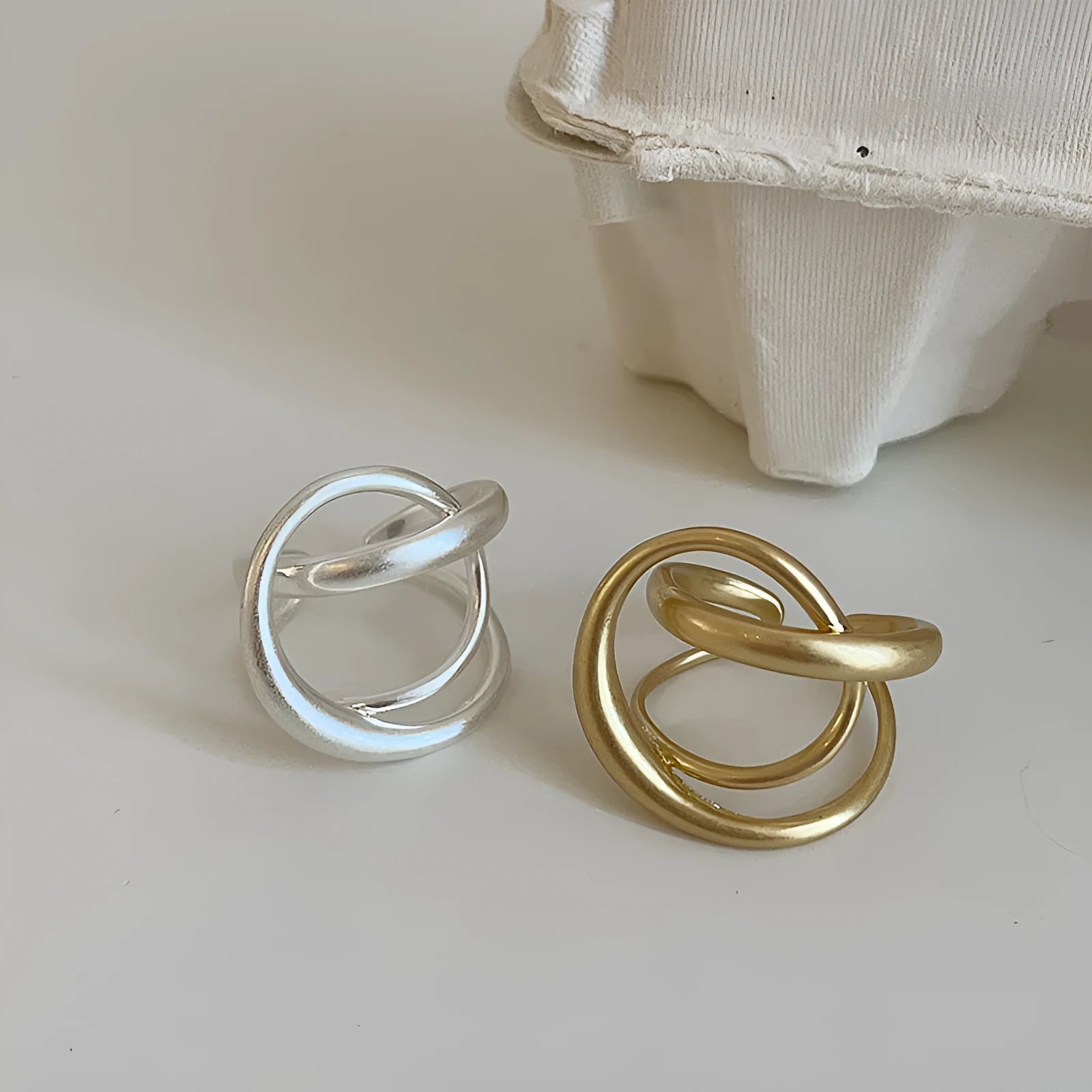 Geometric open ring with interlaced matte metal construction in gold and silver plating options