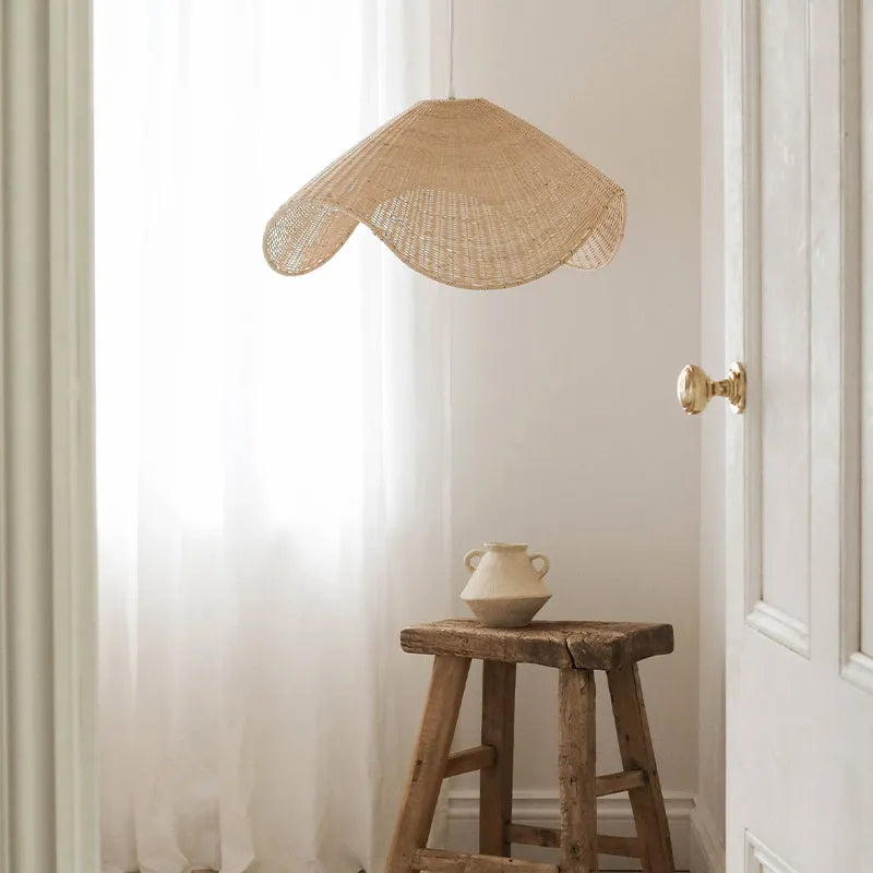 Handmade bamboo and straw rattan chandelier ceiling light with warm LED illumination in a rustic setting.