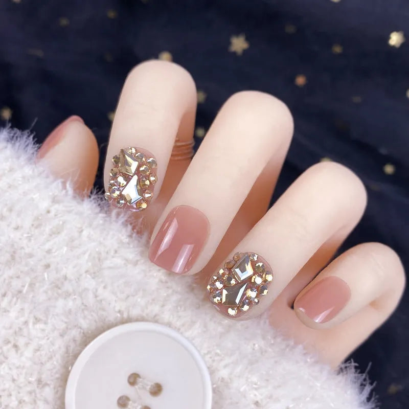 Champagne gold full diamond manicure patches laid out on a surface, showing the sequin finish and adhesive backing