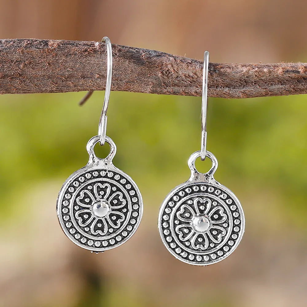 A pair of geometric Bohemian-style retro earrings with a distressed round ethnic print on zinc alloy.