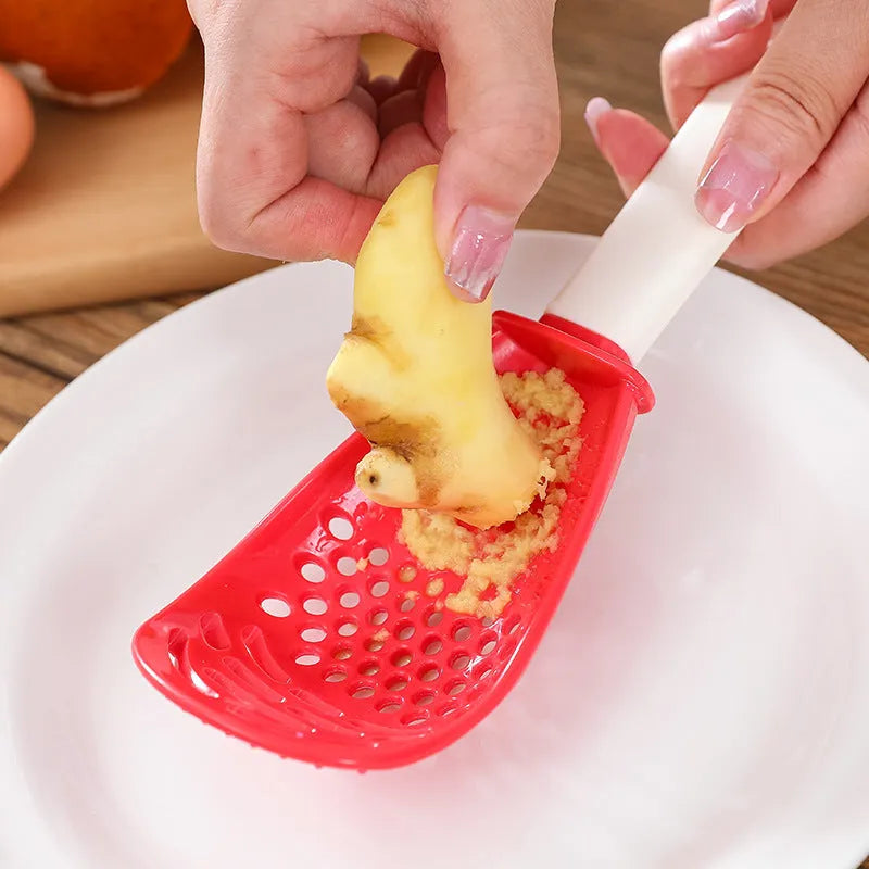 Red and black plastic multifunctional slotted cooking spoon with serrated edges for mashing and grinding.