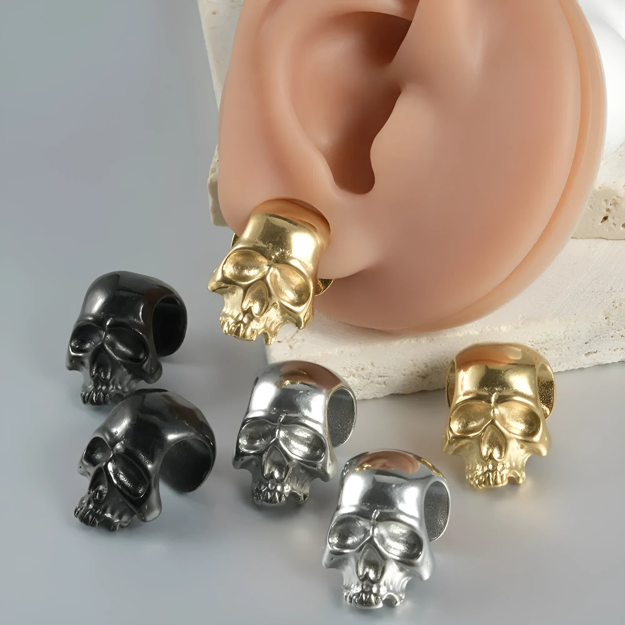 Stainless steel hollow skull and Buddha head geometric earrings in various electroplated colours.