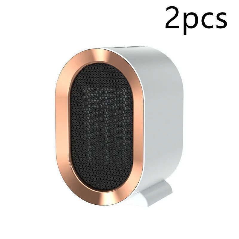 Compact black desktop electric fan heater with mechanical control knobs on a wooden desk.