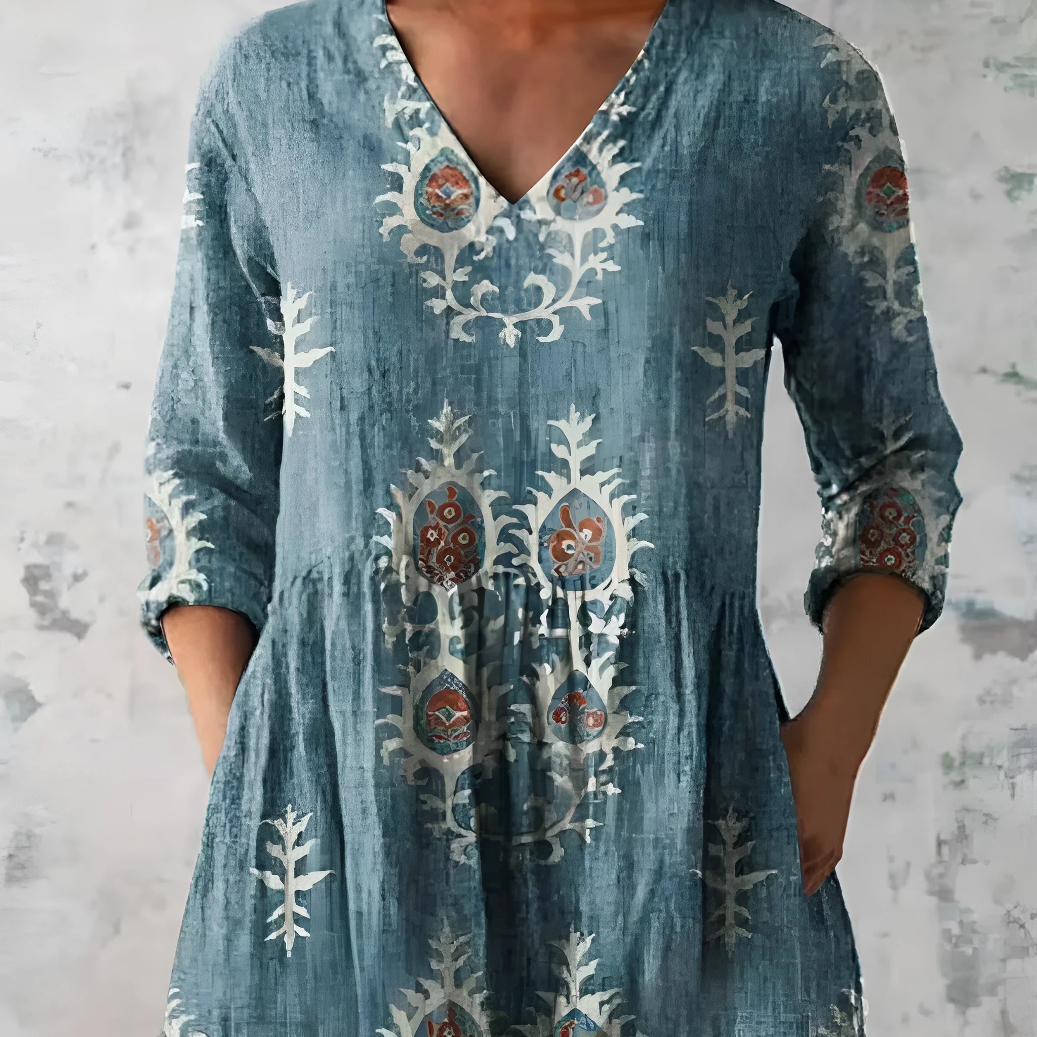 A woman wearing a printed, loose-fitting dress with a wide waist and three-quarter length sleeves.