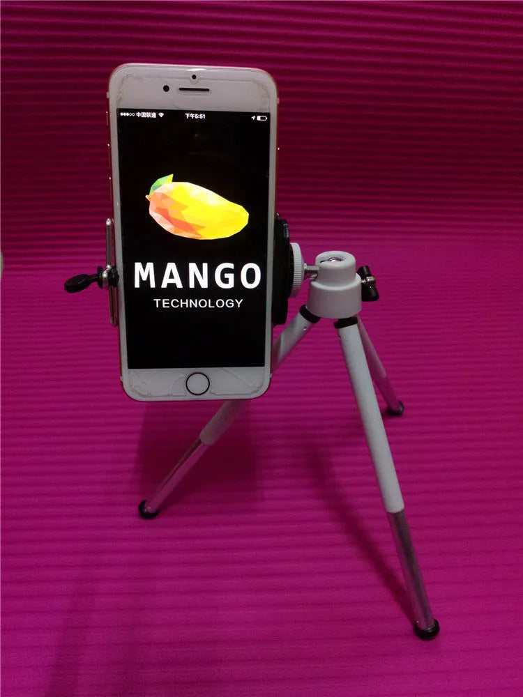 A black or silver desktop phone holder with a two-section adjustable bracket on a wooden desk.