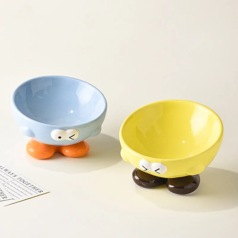 Oblique ceramic pet bowl with cute expression pattern, tall design for cervical spine protection
