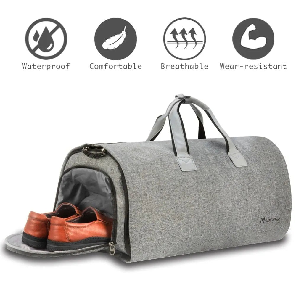 Travel garment bag in black and gray with adjustable shoulder strap, hanging suit carrier, and multiple pockets on a neutral background