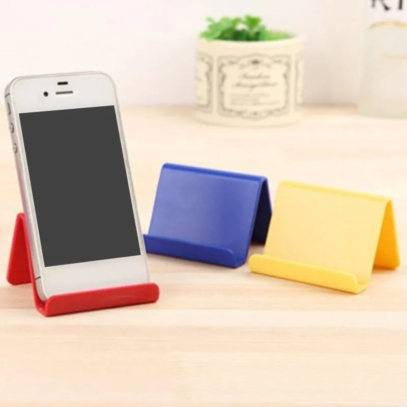 Plastic mobile phone stand in irregular shape on a desk, 6x4.5cm, in blue colour