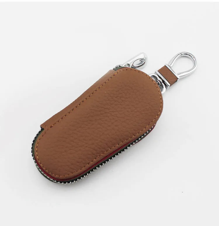 Brown leather car universal key case holding a car key on a white background