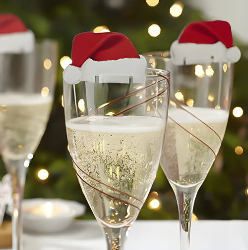 10 red paper Santa hat wine glass toppers on a Christmas table
