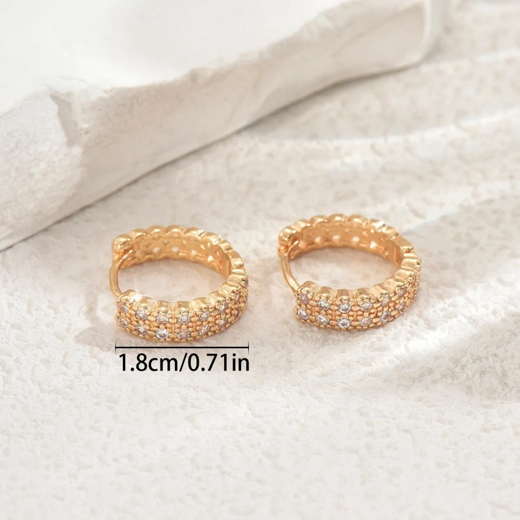 A pair of women's geometric pattern ear studs made from copper, showing round, dot, and ring design details.
