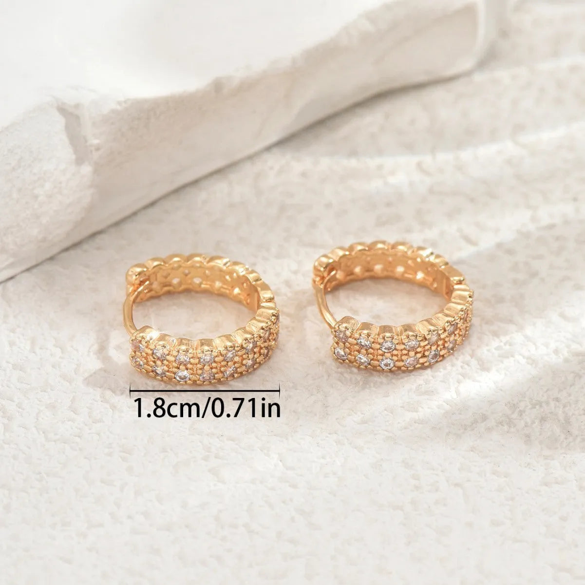 A pair of women's geometric pattern ear studs made from copper, showing round, dot, and ring design details.