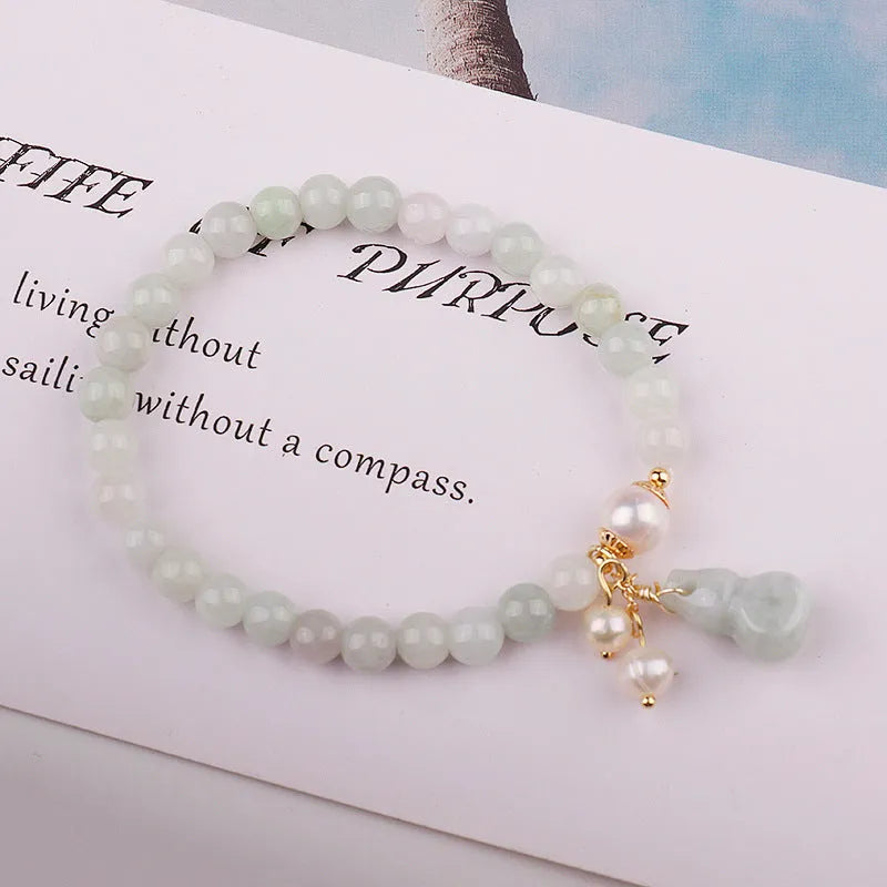 Chinese style women's jade bracelet with traditional gourd design featuring emerald jade insets and pearl elements
