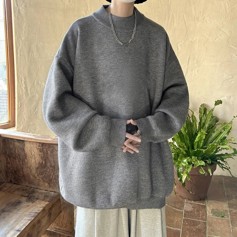 Man wearing a loose grey round neck long sleeve polyester sweater for casual spring or autumn attire.