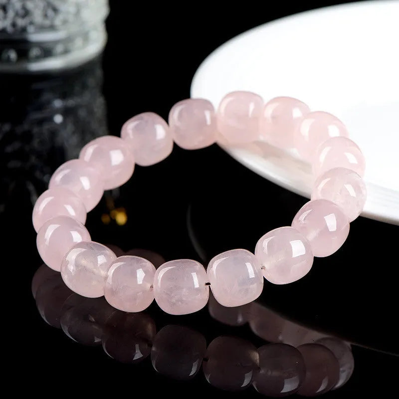 Pink crystal barrel bead bracelet on a black adjustable cord, showing geometric design.