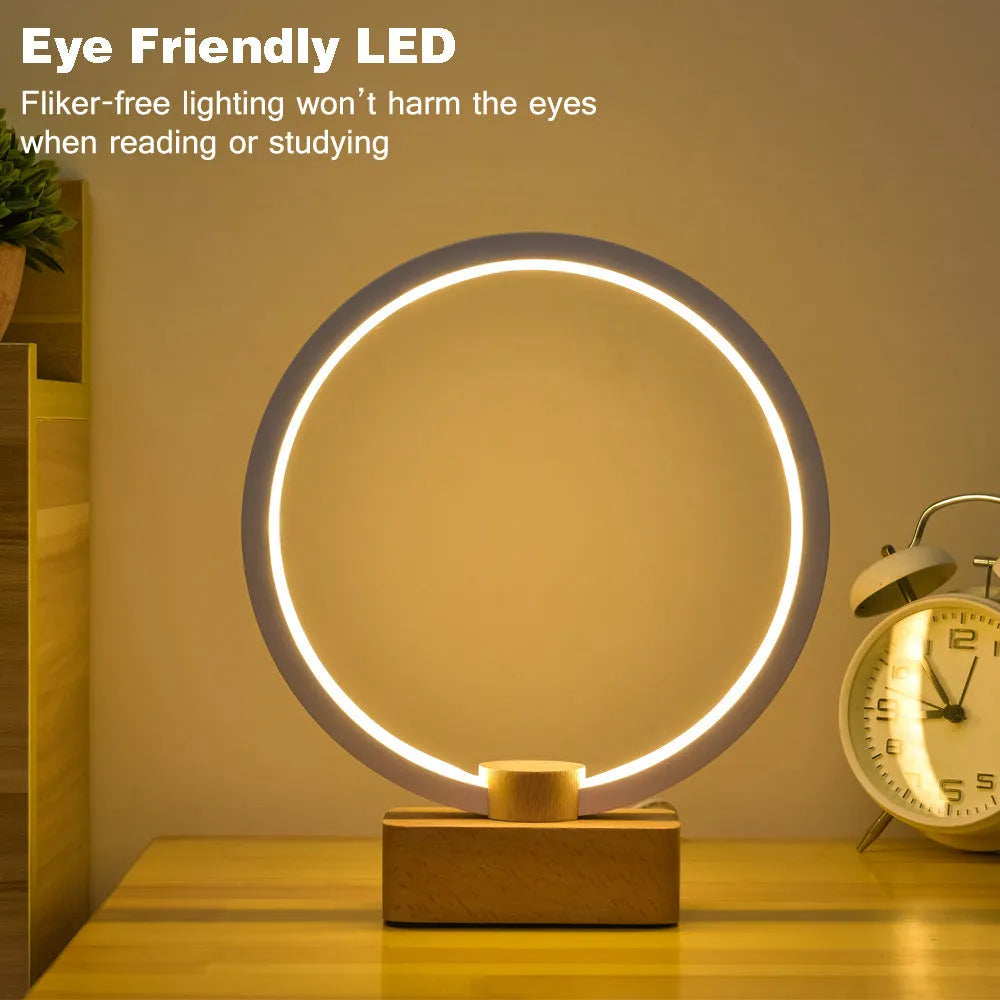 Round small solid wood and bamboo USB-powered LED night lamp on a table.
