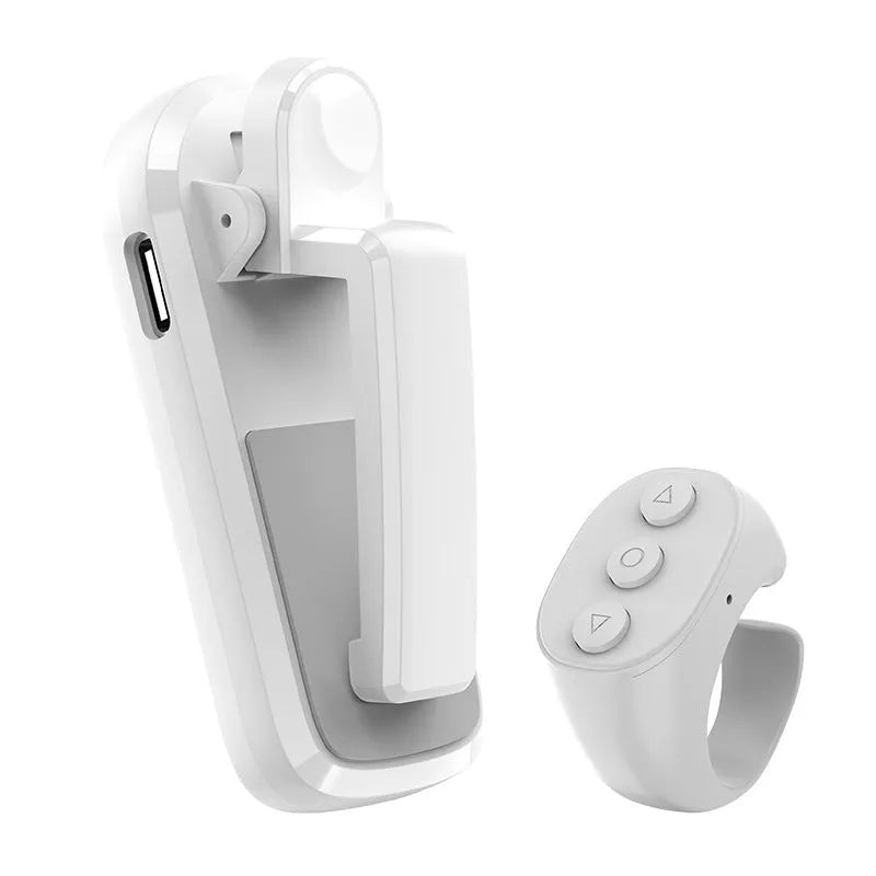 Black wireless page turner remote and clicker for tablets on a wooden table.
